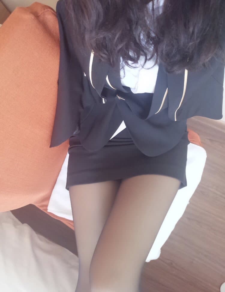 Office scene with woman in black pantyhose and pencil skirt crossing legs under a desk